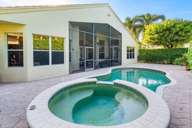 view of swimming pool featuring an in ground hot tub, a patio area, and a sunroom