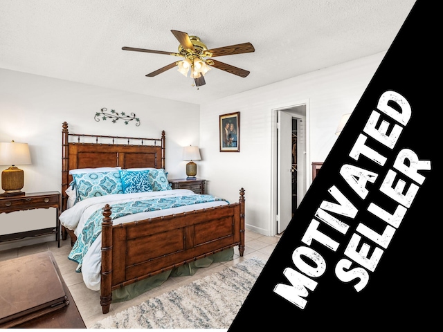 tiled bedroom with ceiling fan and a textured ceiling