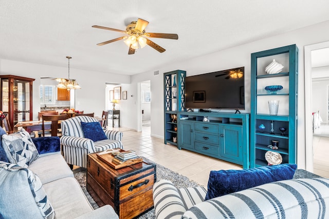 tiled living room featuring ceiling fan with notable chandelier, a wealth of natural light, and a textured ceiling