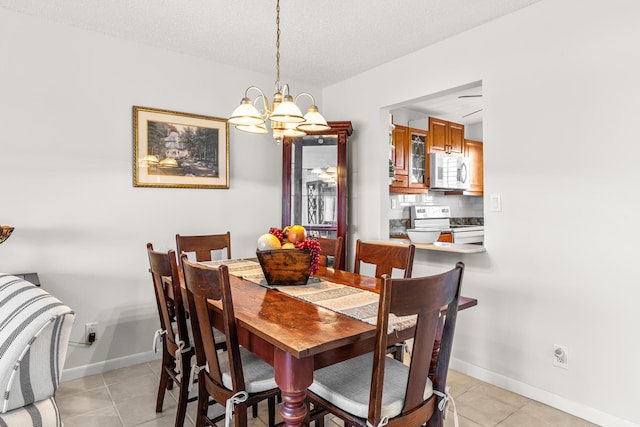 tiled dining room with a textured ceiling and a chandelier