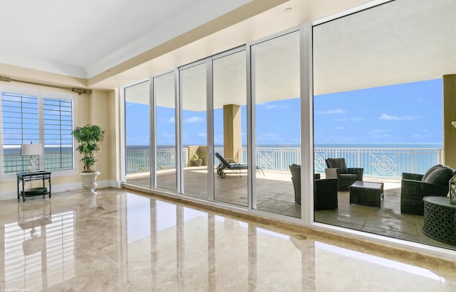 doorway with a healthy amount of sunlight, a water view, and crown molding