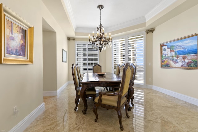 dining space featuring a chandelier, a tray ceiling, and ornamental molding