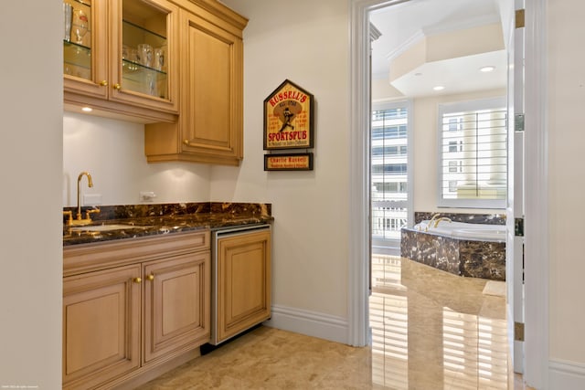 kitchen with crown molding, sink, light tile patterned flooring, and dark stone counters