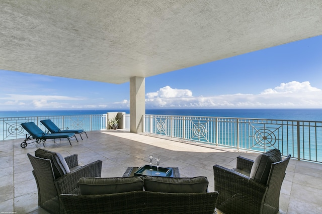 view of patio / terrace featuring an outdoor hangout area, a water view, and a balcony