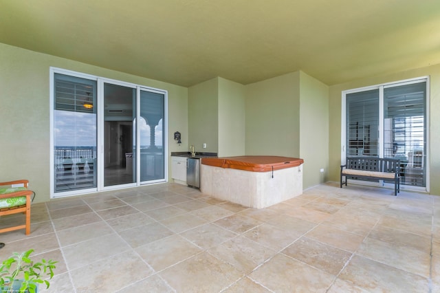 view of patio with sink and a hot tub