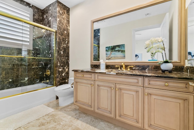 full bathroom with shower / bath combination with glass door, vanity, and toilet