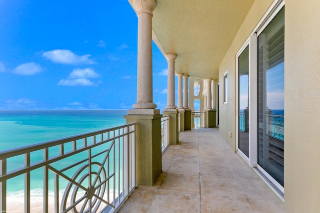 balcony featuring a water view and a view of the beach