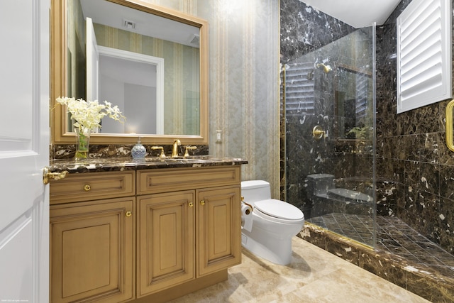 bathroom featuring tiled shower, vanity, and toilet