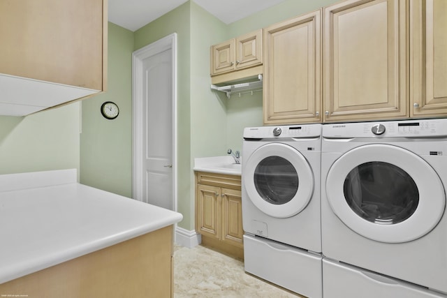 laundry area featuring washer and clothes dryer, cabinets, and sink