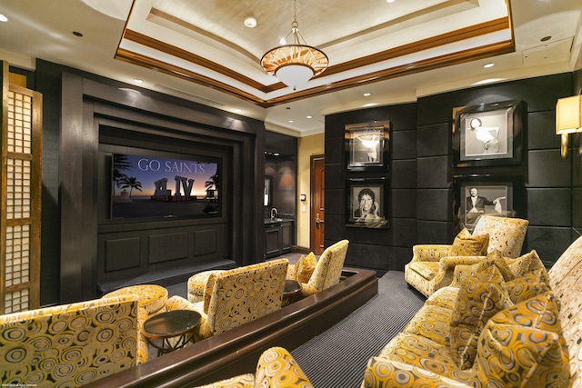 home theater room featuring a tray ceiling, crown molding, and carpet