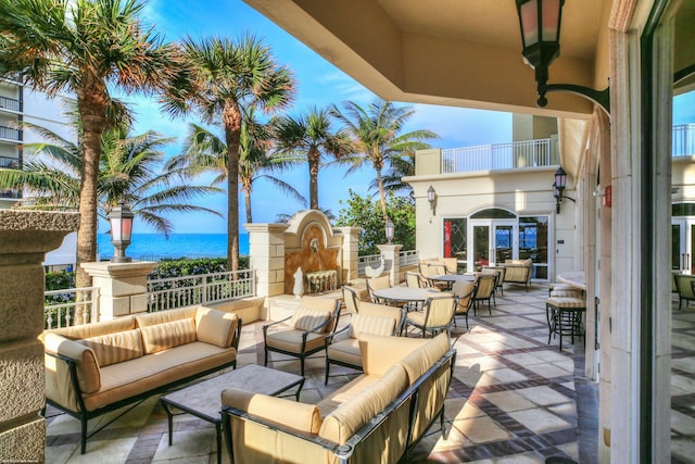 view of patio with outdoor lounge area, a balcony, and a water view