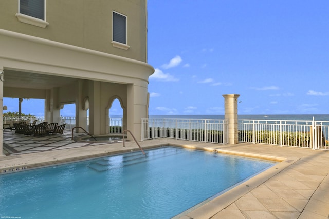 view of pool with a patio area and a water view