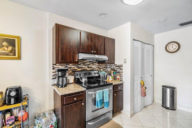 kitchen with stainless steel range with electric stovetop, backsplash, light stone countertops, light tile patterned floors, and dark brown cabinets