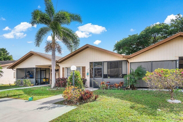 view of front of property with a sunroom and a front lawn