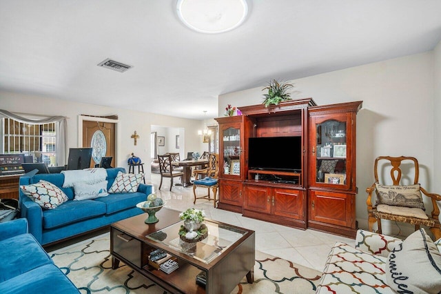 tiled living room with a notable chandelier