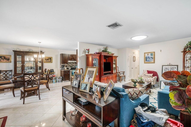 living room with a notable chandelier and light tile patterned flooring