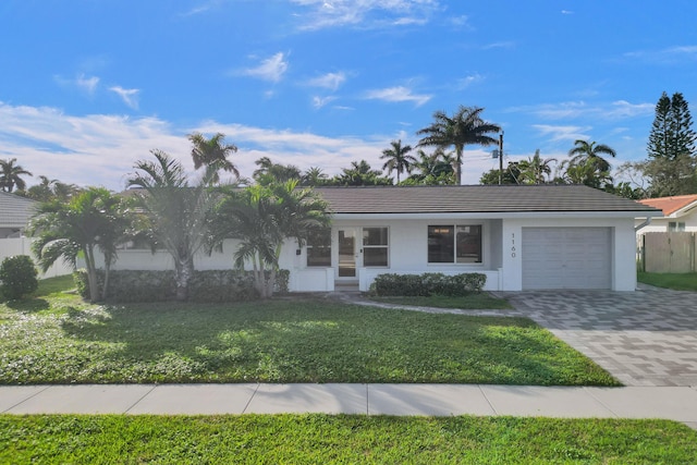 ranch-style home featuring a garage and a front lawn