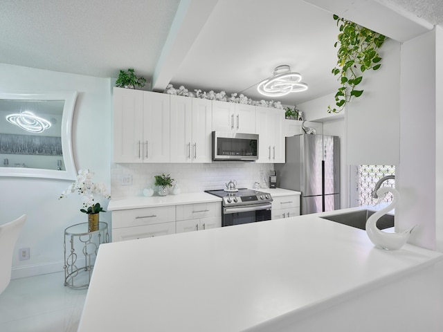 kitchen with sink, beamed ceiling, decorative backsplash, white cabinets, and appliances with stainless steel finishes