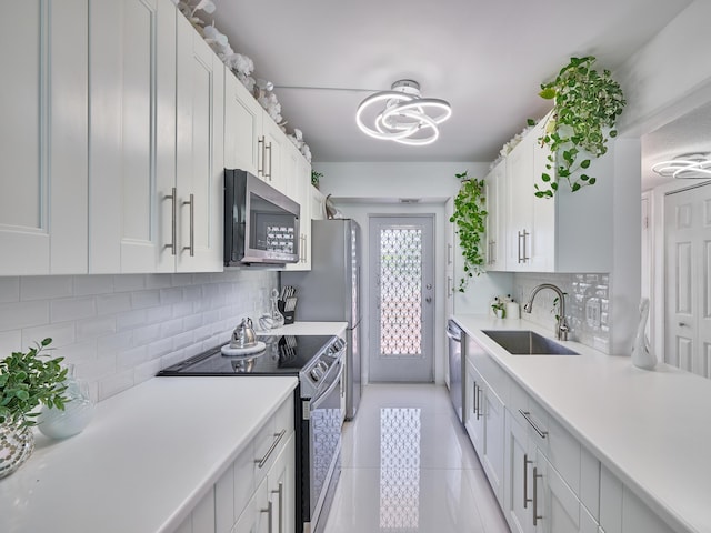 kitchen with light tile patterned floors, white cabinetry, sink, and appliances with stainless steel finishes