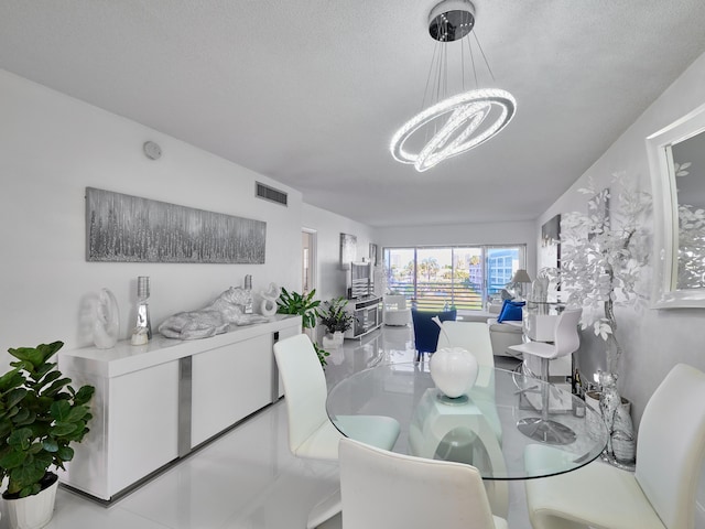 dining room with a notable chandelier and a textured ceiling