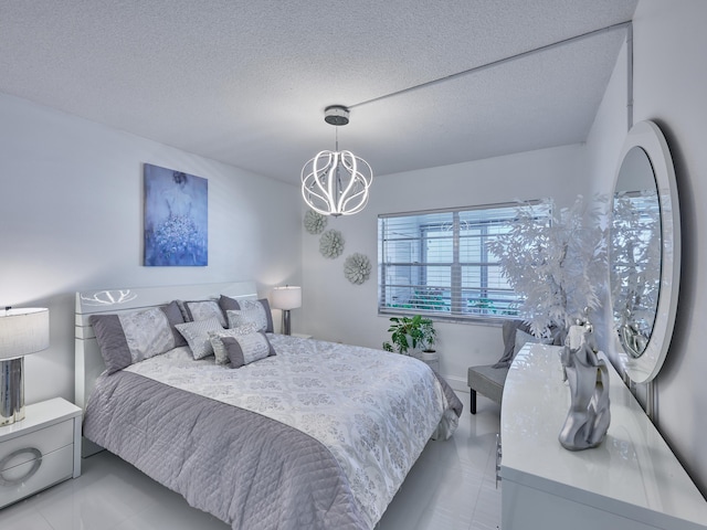 bedroom featuring a chandelier and a textured ceiling