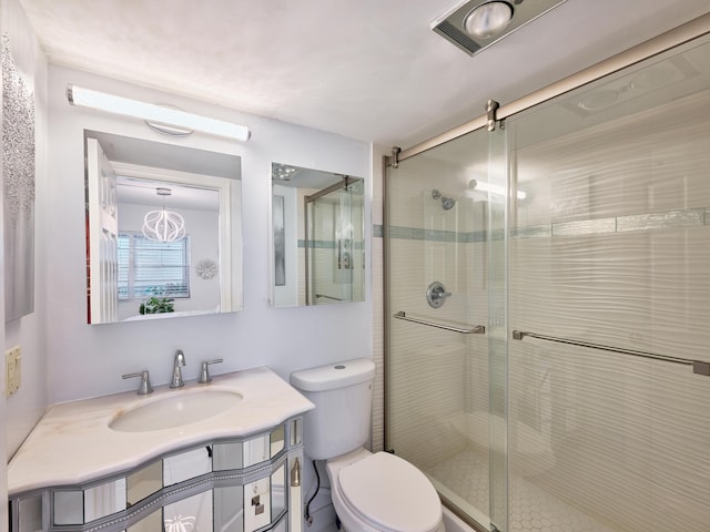 bathroom featuring toilet, an enclosed shower, and vanity