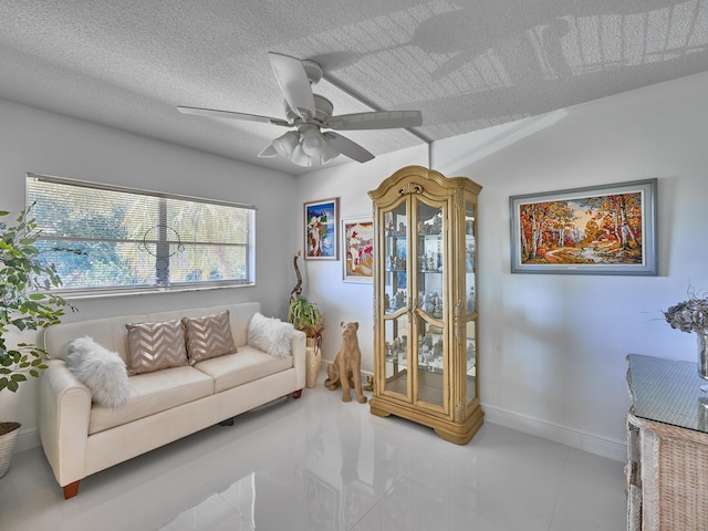 living room with a textured ceiling and ceiling fan