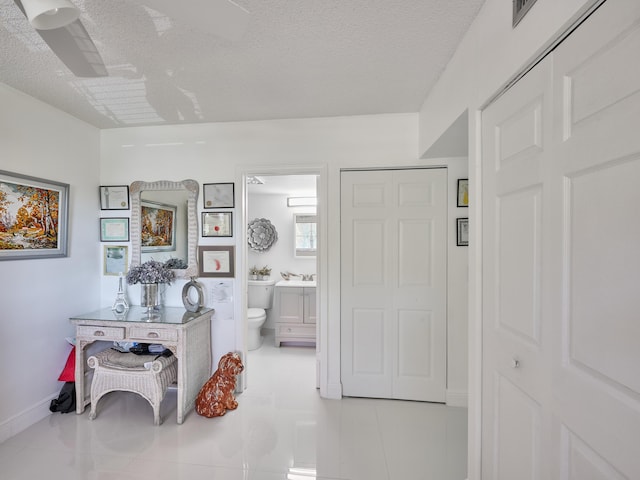 hallway with light tile patterned flooring and a textured ceiling