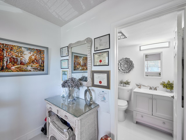 bathroom with tile patterned flooring, vanity, and toilet