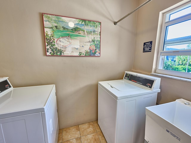 laundry area with light tile patterned floors, sink, and washing machine and clothes dryer