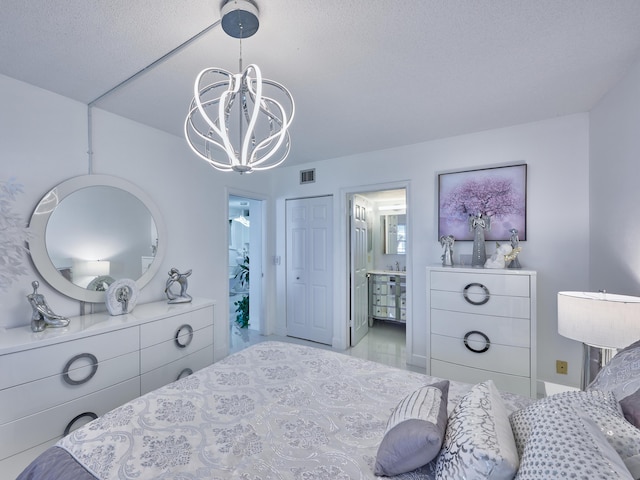 bedroom featuring connected bathroom, a closet, a chandelier, and a textured ceiling