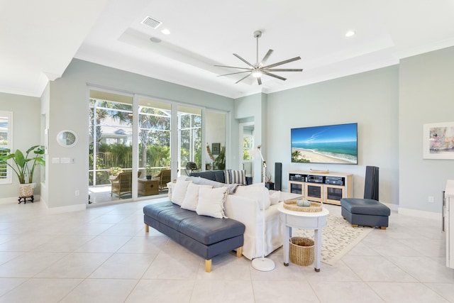 tiled living room featuring ceiling fan, crown molding, and a tray ceiling