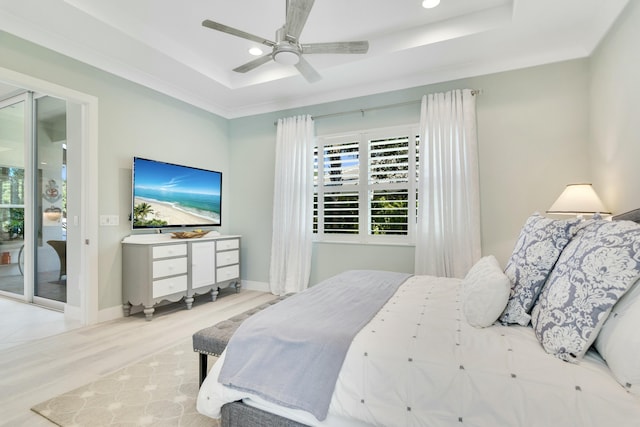 bedroom with access to exterior, a raised ceiling, ceiling fan, crown molding, and light hardwood / wood-style floors