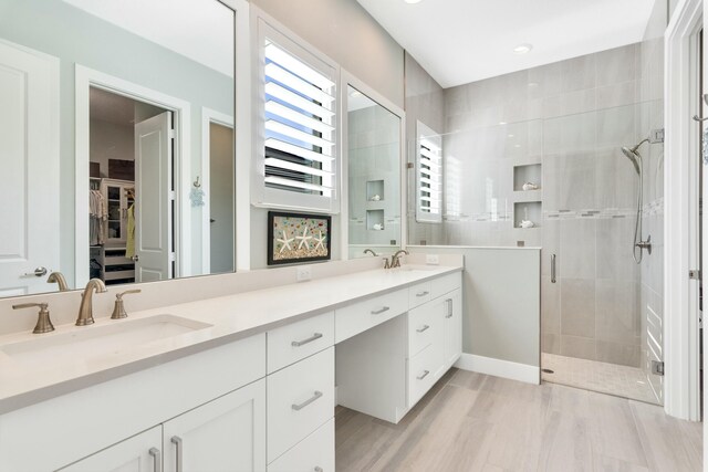 bathroom featuring hardwood / wood-style floors, vanity, and walk in shower