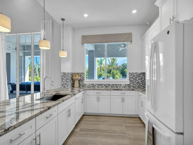 kitchen with white appliances, tasteful backsplash, white cabinetry, and sink