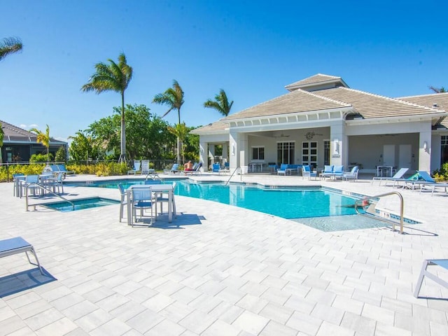 view of swimming pool featuring a hot tub and a patio area