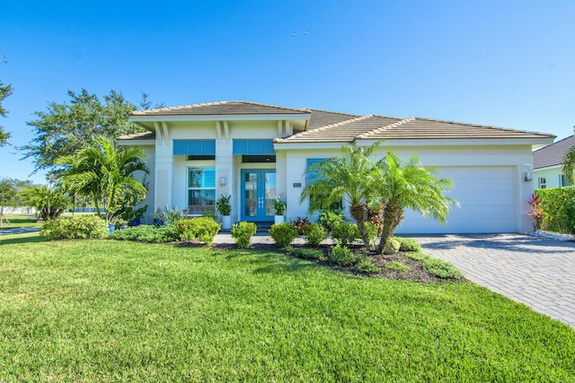 view of front of house with french doors, a garage, and a front lawn