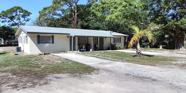 view of front of home featuring concrete block siding, metal roof, and concrete driveway