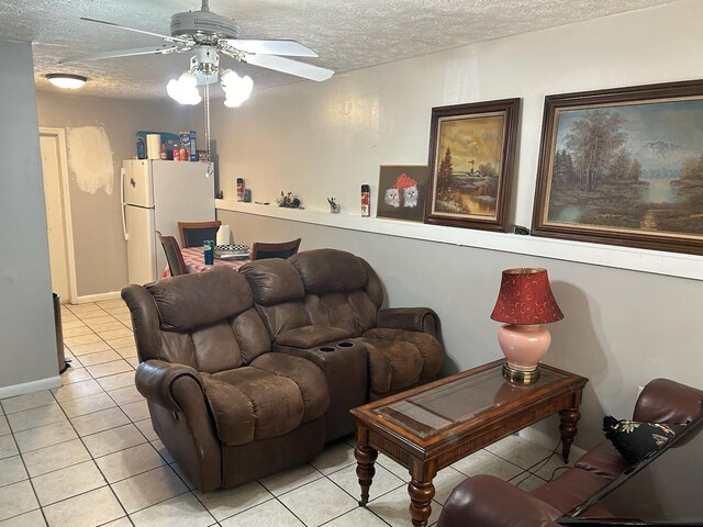 living area featuring a ceiling fan, a textured ceiling, and light tile patterned floors