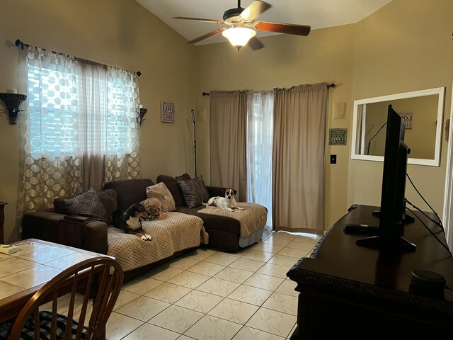 living room featuring ceiling fan, a healthy amount of sunlight, vaulted ceiling, and light tile patterned floors