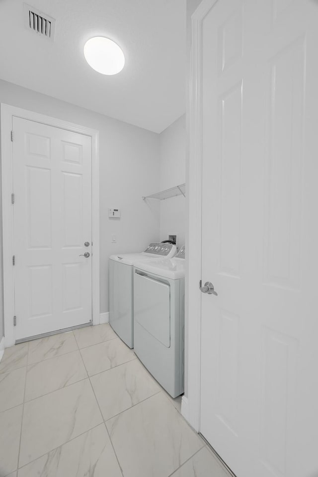 clothes washing area with washer and clothes dryer