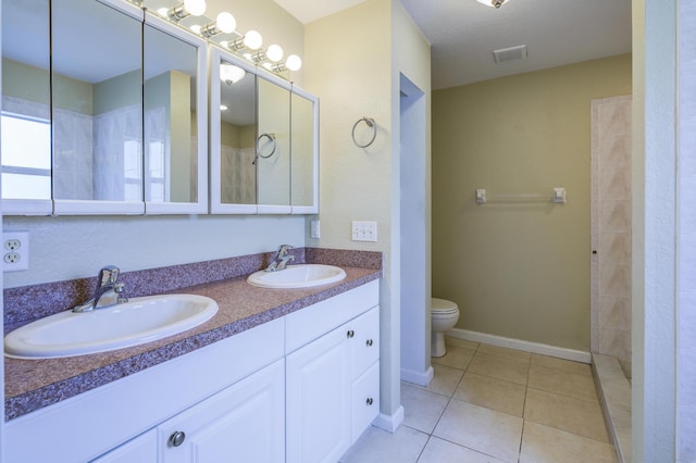 bathroom featuring tile patterned flooring, vanity, and toilet