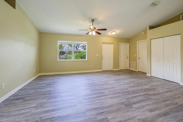 unfurnished bedroom featuring light wood-type flooring, two closets, and ceiling fan