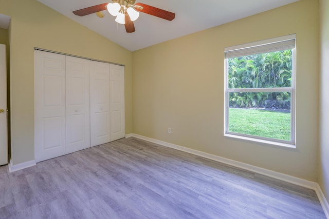 unfurnished bedroom featuring ceiling fan, vaulted ceiling, light hardwood / wood-style flooring, and a closet