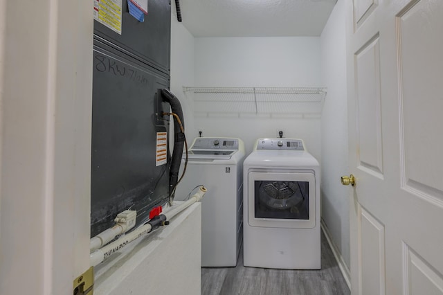 laundry room with hardwood / wood-style flooring and washer and clothes dryer