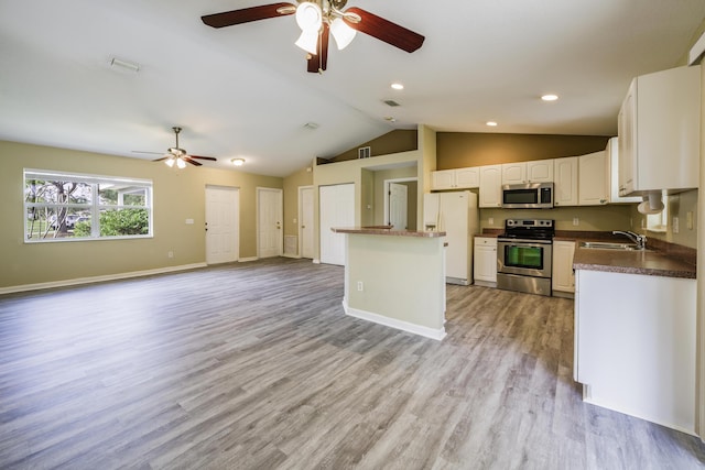 kitchen featuring sink, stainless steel appliances, light hardwood / wood-style flooring, vaulted ceiling, and white cabinets