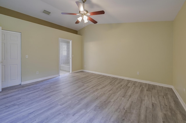 unfurnished room with ceiling fan, vaulted ceiling, and light wood-type flooring