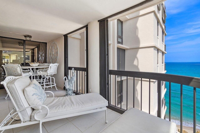 balcony with a water view and a view of the beach