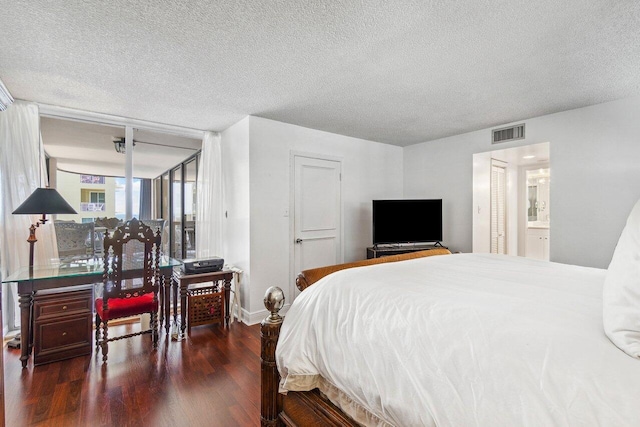 bedroom featuring a textured ceiling, ensuite bathroom, and dark wood-type flooring