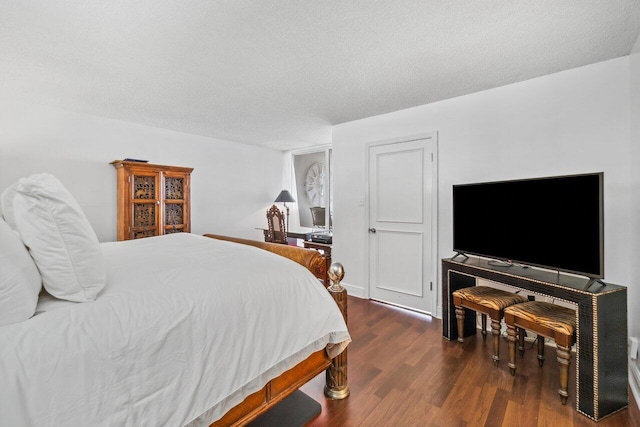 bedroom featuring dark hardwood / wood-style flooring and a textured ceiling